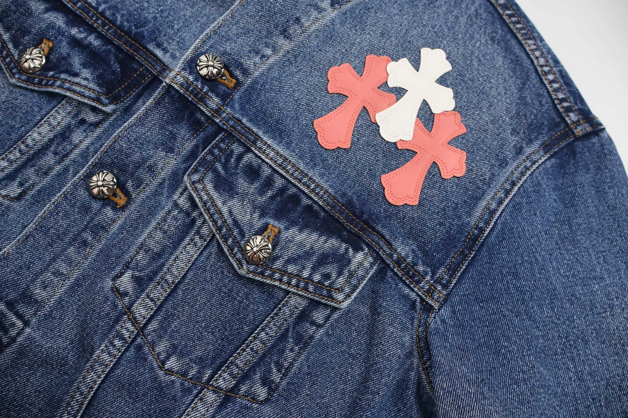 🅿️810 [Exclusive supply] CH Crow Heart Sleeve Cross-Flat Denim Jacket This denim jacket takes the brand's iconic cross element as its core, and stages a wonderful dialogue between hardcore aesthetics and street fashion on retro distressed denim fabric. Design details: the visual fantasy of Gothic symbols, the multi-dimensional expression of the cross totem: the red and white contrasting cross patches are staggered on the chest and back, making the brand more recognizable; the hollow cross pattern leather splicing on the sleeves combines the mystery of religious symbols with the punk-style deconstructed design. Every detail tells the dark aesthetics of Crowe's heart. Retro distressing with denim texture: Selected denim fabrics are treated with distressing techniques to show natural fading and texture, which not only retains the retro accent of denim items, but also adds a casual sense to the overall look. The ingenuity of hardware and tailoring: the metal buttons and hardware all have Croxin's iconic pattern, which shines with exquisite luster under the refraction of light; the neat tailoring of the classic denim jacket is suitable for a variety of wearing scenarios, and can create a strong personal style whether it is layered or worn alone. Croxin's denim jacket is not only a piece of clothing, but also a style badge that highlights unique aesthetics and rebellious attitude. For those who pursue individuality, they can leave their own hardcore mark in the fashion field. Size:S-M-L-XL